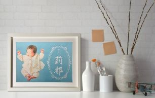 出産祝いの似顔絵プレゼント展示例。背景のパウダーブルーが赤ちゃんの肌色と対比した、白い壁に映えるデザイン性を意識た似顔絵作品。