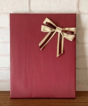 赤い包装紙にゴールドと赤のリボンでラッピング