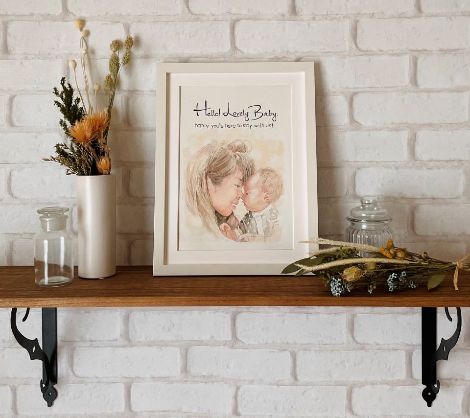 出産祝いの水彩似顔絵展示例。部屋を優しくあたたかい雰囲気にする母子の似顔絵。
